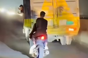 dangerous bike stunts on highway behind fast moving truck